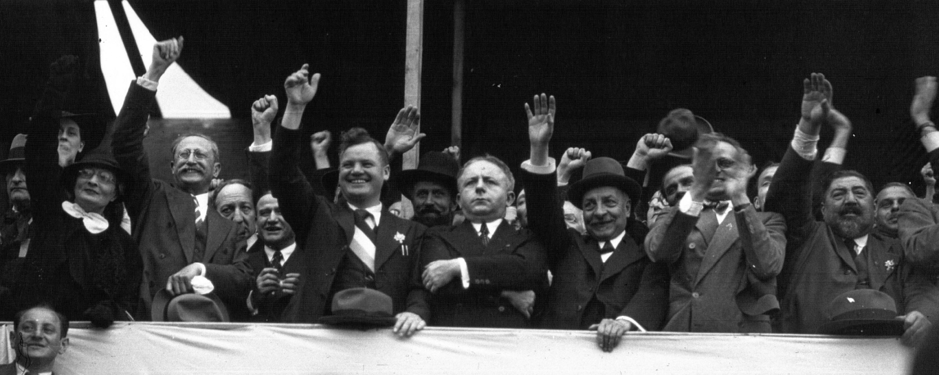 Grand rassemblement populaire en 1936, foule dense devant une tribune.