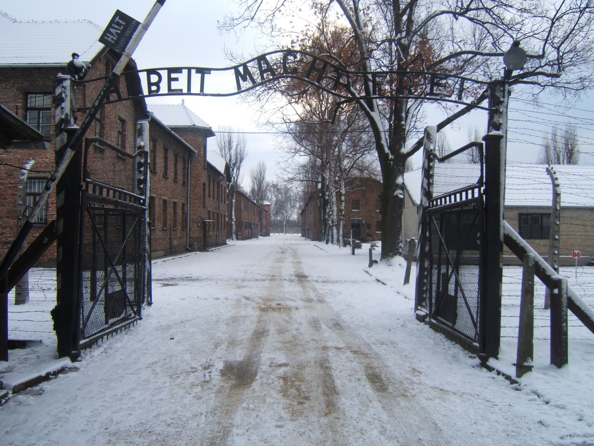 Entrée du camp d'Auschwitz I sous la neige, portail et inscription.