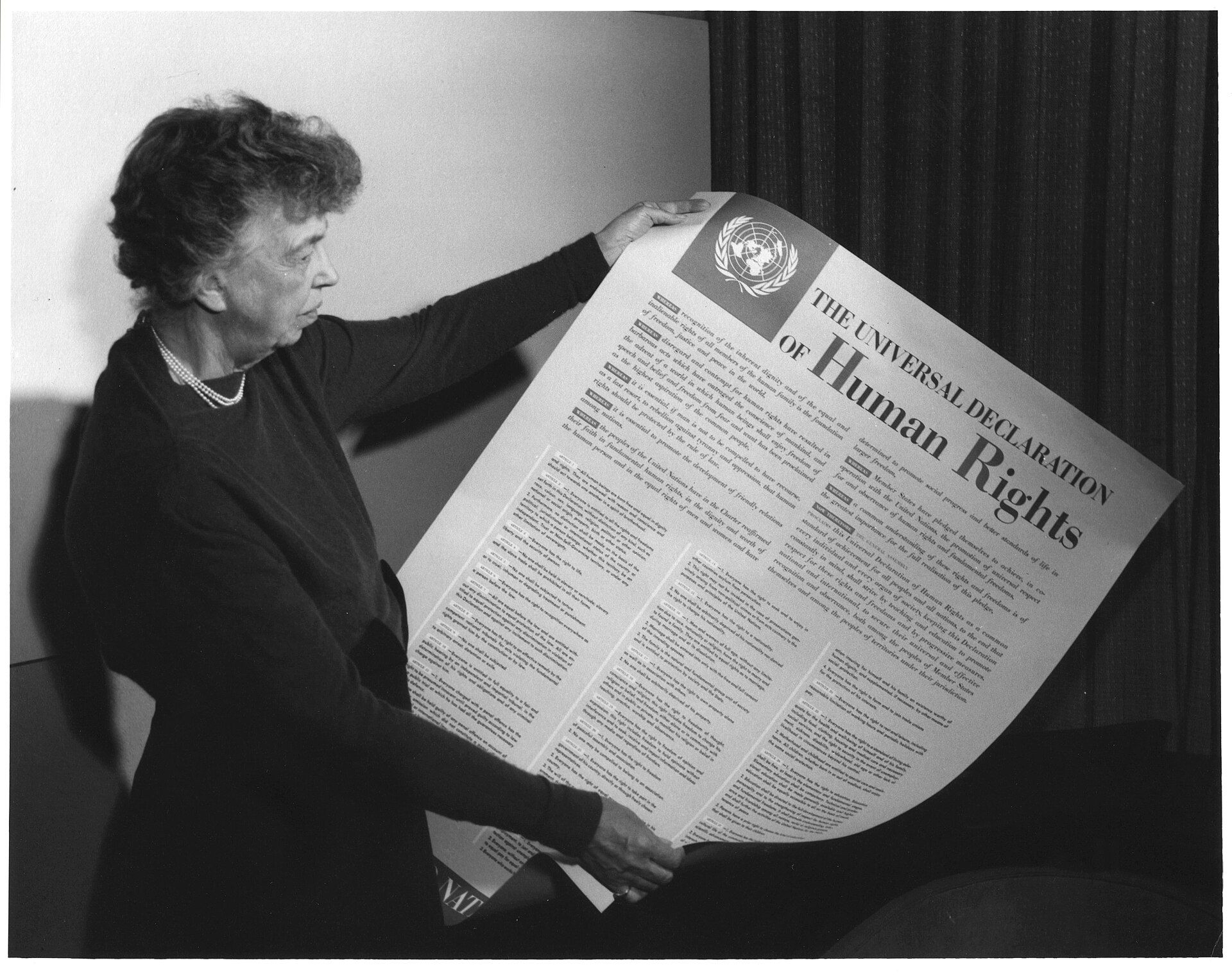 Eleanor Roosevelt tenant une affiche de la Déclaration universelle des droits de l'homme.