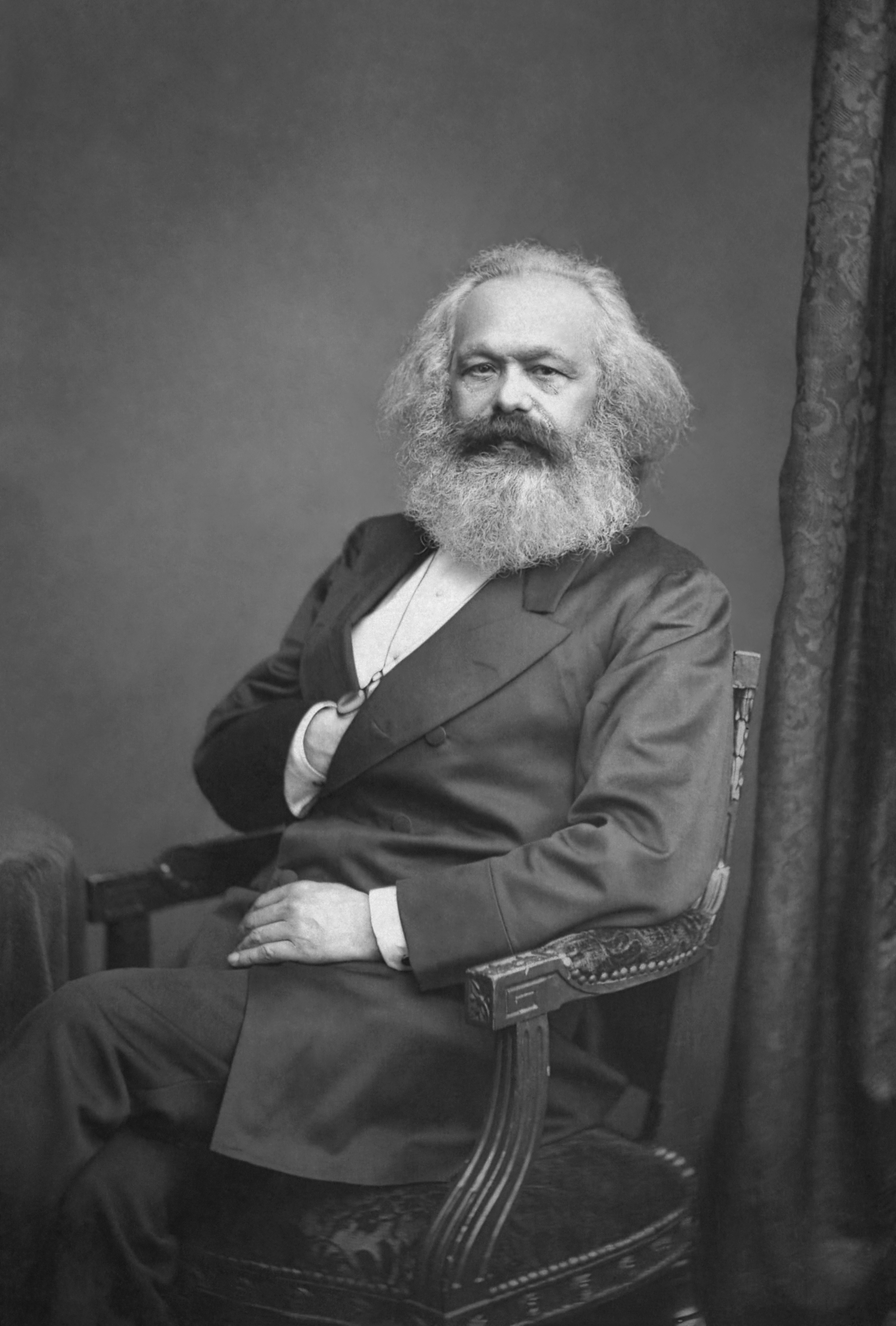 Photographie de Karl Marx, barbe blanche et costume sombre.